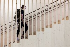 Luontokeskus Haltian portaikko, joka on toteutettu Rema-levyillä. Portaikkoa ylöspäin kiipeää nainen, jolla on retkeilyvaatteet ja reppu selässä.